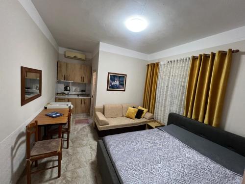 Un dormitorio con una cama y un escritorio y una cocina. en Villa Roel 1 -apartments, en Vlorë