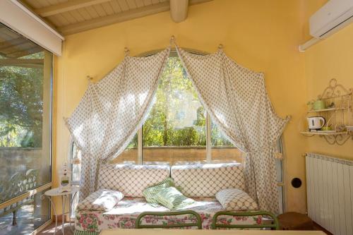 a window with curtains and a couch in a room at San Giovanni Residence in Peccioli