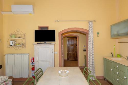 a dining room with a table and a tv on the wall at San Giovanni Residence in Peccioli