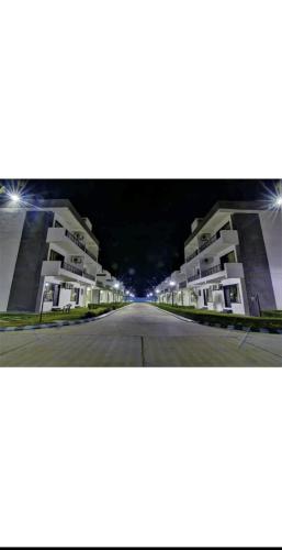 an empty street in front of apartment buildings at night at Hotel Super Townhouse Omaxe Eternity vrindavan near Prem Mandir in Vrindāvan
