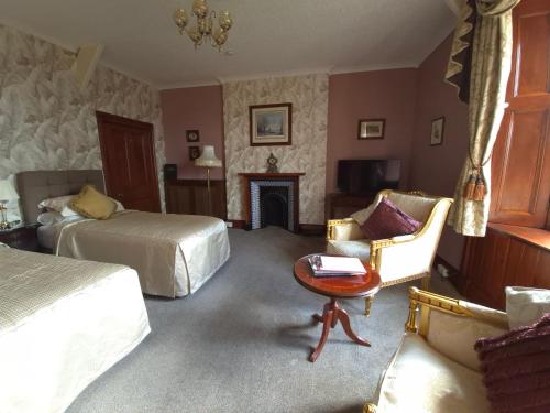 a hotel room with two beds and a fireplace at St David's Guesthouse in Haverfordwest