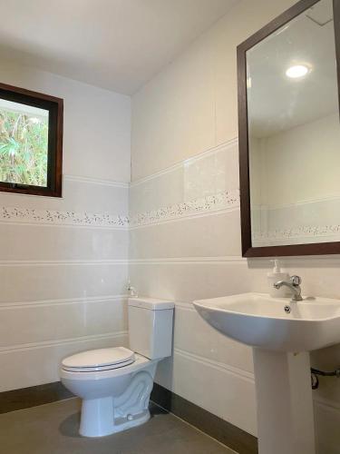 a bathroom with a white toilet and a sink at Secluded 4BD Beach Villa, Fast Wifi, Pet Friendly in Lian