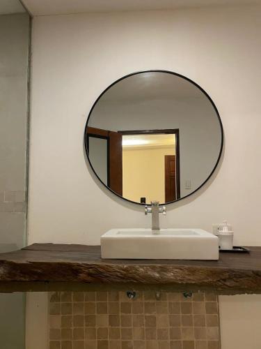 a bathroom sink with a round mirror on a counter at Secluded 4BD Beach Villa, Fast Wifi, Pet Friendly in Lian