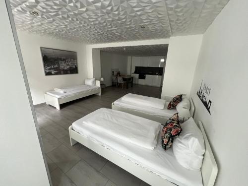 a bedroom with two beds and a living room at Wohnen auf Zeit Apartments mit E-Ladesäulen Monteure in Osnabrück