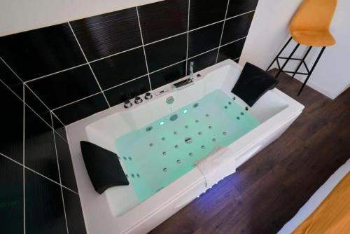 un baño con bañera con un diseño ecológico en NG Prestige - Suite Soleil Doré - Balnéo - Cuisine - Jardin, en Roubaix