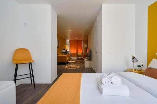 Un dormitorio con una cama blanca con toallas. en NG Prestige - Suite Soleil Doré - Balnéo - Cuisine - Jardin, en Roubaix