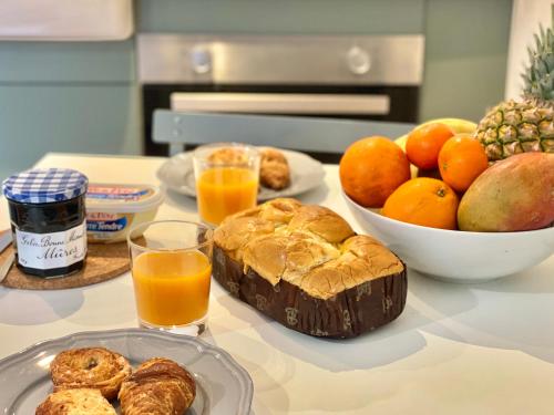 a table with a breakfast of orange juice and pastries at " Studio Vasconia " Hyper Centre - Mezzanine -Wifi in Muret