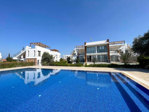 a large swimming pool in front of some buildings at Olive Branch by HolidayKeys in Ayyorgi