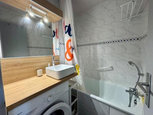 une salle de bain avec une machine à laver et un lavabo dans l'établissement Appartement - Cap d'Agde, au Cap d'Agde