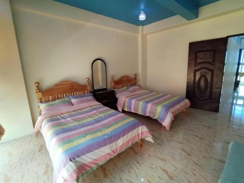 a bedroom with two beds and a mirror at YahVilla Homestay in Baguio