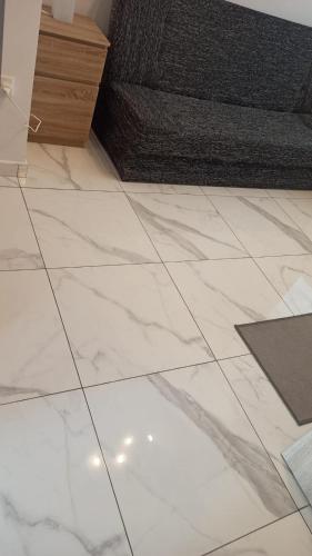 a white tile floor in a living room with a couch at Flat 1 Central Apartment in Swieqi in Is-Swieqi