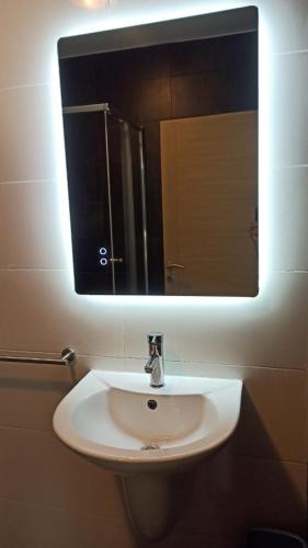 a white sink in a bathroom with a mirror at Flat 1 Central Apartment in Swieqi in Is-Swieqi