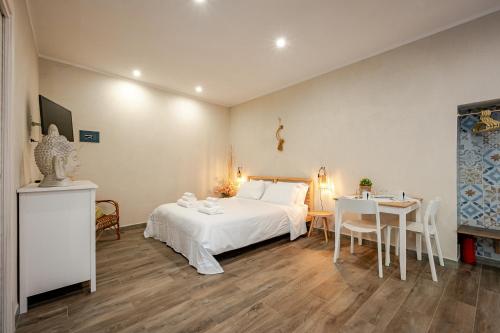 a bedroom with a white bed and a table and chairs at Incanto Manarola in Manarola