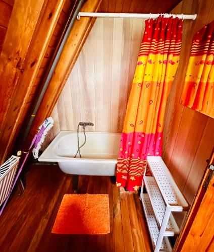a bathroom with a tub and a shower curtain at Bacówka w Karkonoszach - Domek na wyłączność w Karpaczu blisko wyciągu i szlaków in Karpacz