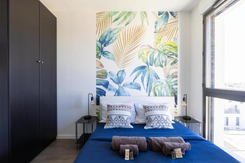 a bedroom with a blue bed with two towels on it at Duplex Terrasse Parking - Paris Montreuil in Montreuil