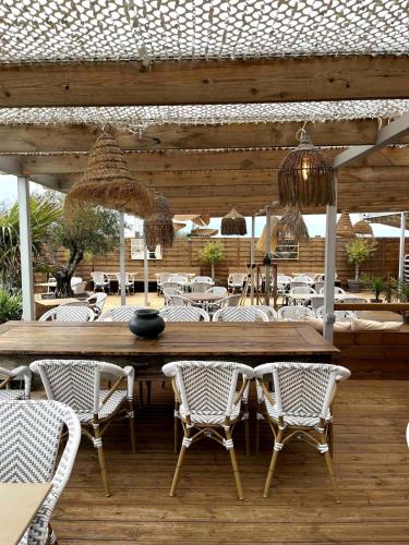 une table et des chaises en bois dans un restaurant avec une table dans l'établissement Joli T2 Lumineux proche mer !, à Angoulins-sur-Mer