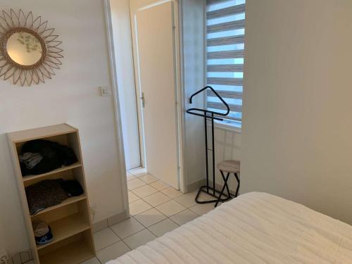 une chambre avec un lit et un miroir au mur dans l'établissement Le Pavois des mers - Saint Hilaire de RIez, à Saint-Hilaire-de-Riez