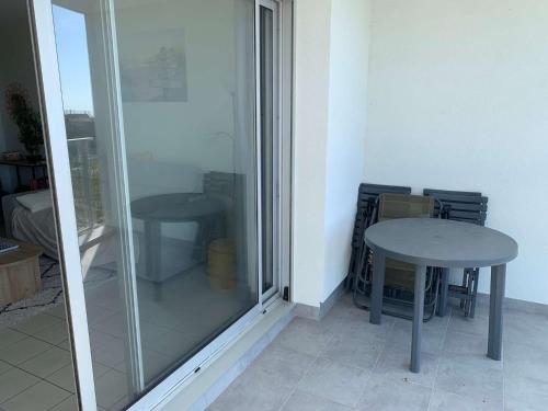Cette chambre dispose d'une table et d'une fenêtre en verre. dans l'établissement Le Pavois des mers - Saint Hilaire de RIez, à Saint-Hilaire-de-Riez