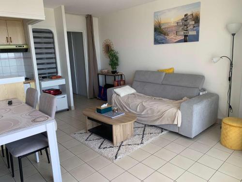 un salon avec un canapé et une table dans l'établissement Le Pavois des mers - Saint Hilaire de RIez, à Saint-Hilaire-de-Riez