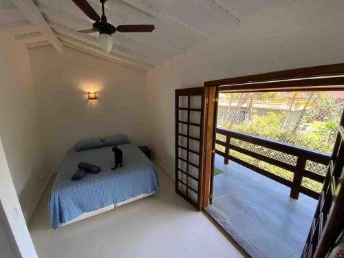 a bedroom with a bed and a sliding glass door at Casa de Condomínio em Maresias próximo a praia! in São Sebastião