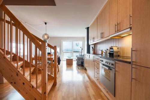 eine große Küche mit Holzschränken und einer Treppe in der Unterkunft Modern Seahouse in Svolvær with stunning views! in Svolvær