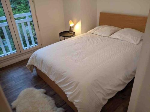 una camera da letto con un letto bianco e una finestra di Capbreton 2 bedroom apartment between forest and beach a Capbreton