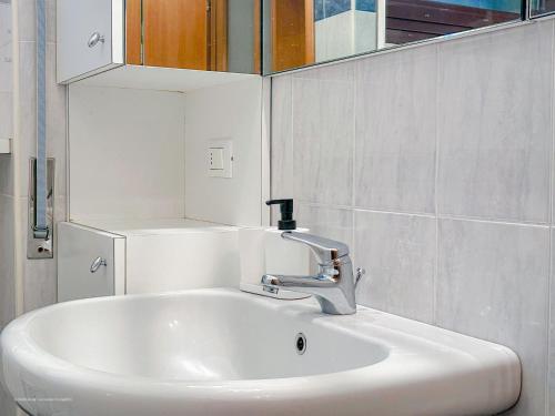 un lavandino bianco in un bagno con uno specchio di Brunacci BEleven Suite - 5 min dai Navigli a Milano