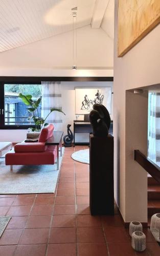 a living room with a red couch and a table at Charmantes Haus mit Gartenoase in Hilden