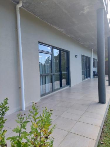 an empty white building with columns and windows at Waiwera Clifftop - Eagle's Rest in Waiwera