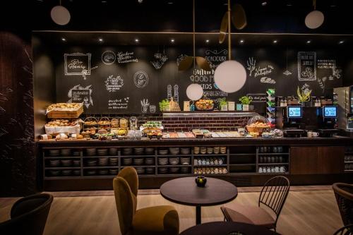 a restaurant with a counter with a table and chairs at Motel One München Hauptbahnhof in Munich