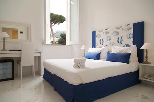 a bedroom with a blue and white bed and a desk at Hotel Crawford in Sant'Agnello