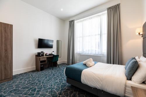 a hotel room with a bed and a tv at The J Hyde Park Hotel in London