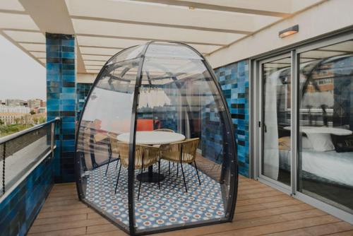 a glass dome on a balcony with a table in it at Hotel Dimar in Valencia
