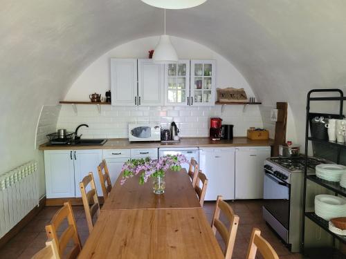 a kitchen with a wooden table with flowers on it at Leśne Apartamenty in Zieleniec