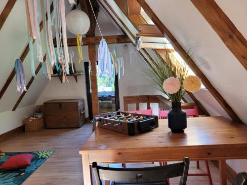 a room with a wooden table with a vase of flowers at Leśne Apartamenty in Zieleniec