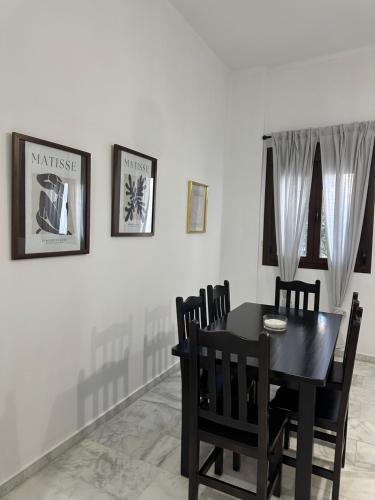 Un comedor con una mesa y sillas negras. en Apartamentos La Bola 94, en Ronda