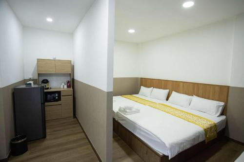 Un dormitorio con una cama y una pequeña cocina. en Dado9home, en Klong Toi