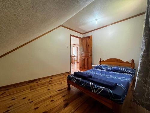 a bedroom with a bed and a wooden floor at VidHuset Homestay Sagada in Sagada