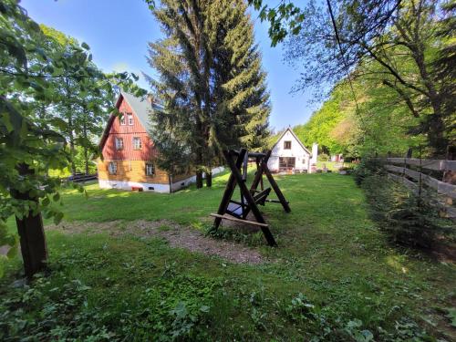 a sculpture in the middle of a yard with houses at Leśne Apartamenty in Zieleniec
