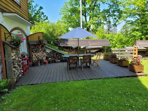 a patio with a table and an umbrella at Leśne Apartamenty in Zieleniec