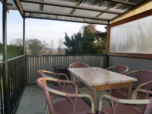 a table and chairs on a patio with a pergola at Ferienwohnungen Naschkatze in Krummin