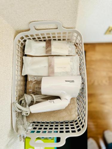 a white laundry basket with hair dryer and other items at JOJO TC house in Osaka