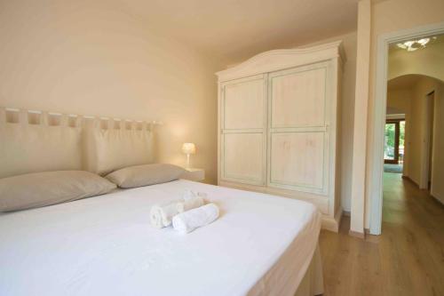 a bedroom with a white bed with towels on it at Swimming Pool & Free Park Porto Rotondo Center in Porto Rotondo