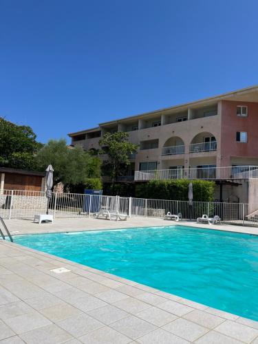 une piscine devant un immeuble dans l'établissement Studio, à Saint-Florent