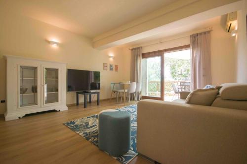 a living room with a couch and a television at Swimming Pool & Free Park Porto Rotondo Center in Porto Rotondo