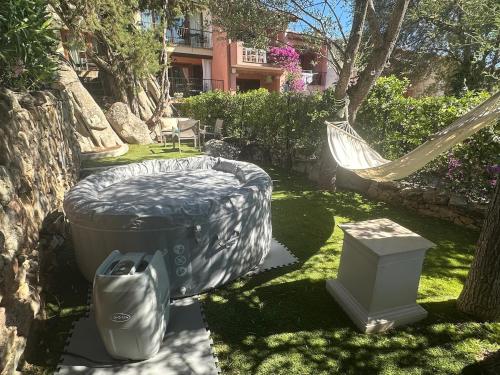 a hammock in a yard with a hammock and a hamminet at Swimming Pool & Free Park Porto Rotondo Center in Porto Rotondo