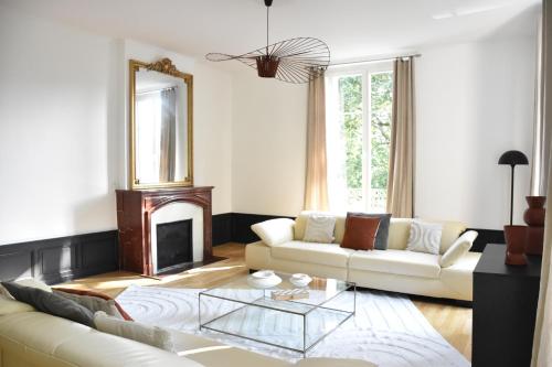 un salon avec un canapé blanc et une cheminée dans l'établissement L'appartement du parc, à Nancy