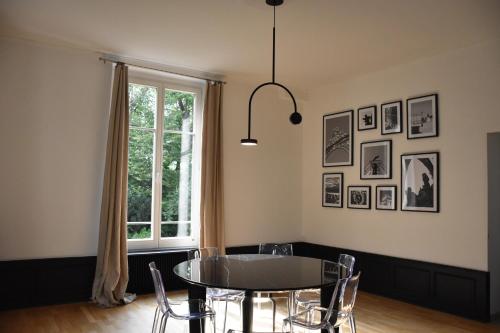 une salle à manger avec une table et des chaises et une fenêtre dans l'établissement L'appartement du parc, à Nancy