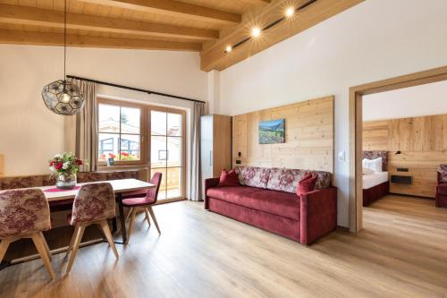 フューゲンにあるHochleger Appartement Zillertal FUZ1001の赤いソファとテーブルのあるリビングルーム