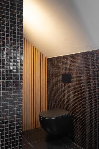 a bathroom with a black toilet in a room at Luxe city villa te Hasselt in Hasselt